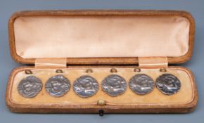 A cased set of Edward VII hallmarked silver buttons of Art Nouveau design depicting a lady playing