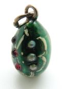 A silver egg pendant set with red cabochons and seed pearls,