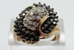 A 9ct gold ring set with clear and black diamonds in a cluster, size P, 5.