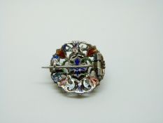 An Austro-Hungarian silver brooch set with a large garnet cabochon to the centre surrounded by blue