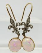 A pair of Victorian earrings set with an opal cabochon and diamonds in the form of a fleur de lys,