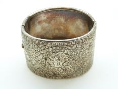 A white metal Victorian bangle with chased foliate design