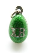 A Russian silver egg pendant set with green enamel, 'XB' to one side and a seed pearl to the other,