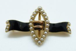 A 15ct gold Edwardian brooch in the form of a buckle set with seed pearls and black enamel