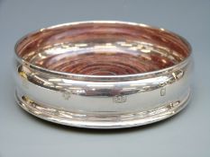 A hallmarked silver wine coaster with feature millennium hallmarks,