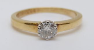 An 18ct gold ring set with a round cut diamond of approximately 0.