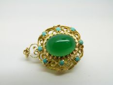 An 18ct gold pendant set with a large green cabochon to each side surrounded by further turquoise