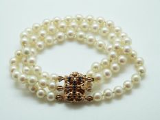 A three strand cultured pearl bracelet with 9ct gold clasp set with sapphires