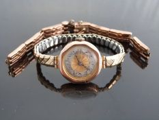 A 9ct gold ladies wristwatch with Arabic numerals, two-tone silver and gold face, blued hands,