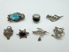 A silver brooch in the form of an owl set with marcasite and a blue gemstone,