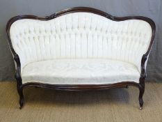 A Victorian upholstered sofa with show wood frame