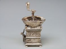 A white metal novelty coffee grinder with rotating mechanism marked with Medusa-Oro,