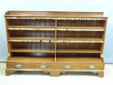An 19thC or early 20thC inlaid mahogany bookcase with four drawers under by Goodall,