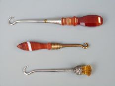 A hallmarked silver and Scottish thistle button hook together with two banded agate handled