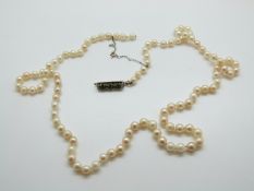 A single strand of cultured pearls with emerald and diamond set clasp