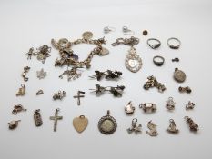 A silver charm bracelet and a large quantity of silver charms, rings, pendants,