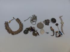 A silver brooch in the form of a bird with gold detail, silver watch,