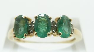 A 9ct gold ring set with three oval emeralds and diamonds, size R/S, 2.