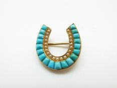 A Victorian yellow metal brooch in the form of a horseshoe set with turquoise cabochons and seed
