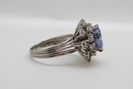 A platinum ring set with a cushion cut natural cornflower blue sapphire of approximately 5.