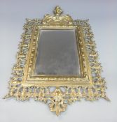 An ornate brass framed bevelled edge mirror marked verso PP,