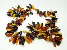 An amber necklace of irregular shaped pieces of various colours, 92g, 59cm long.