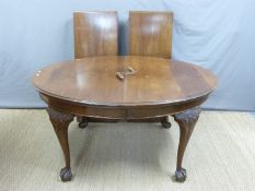 A late 19thC/early 20thC oval mahogany wind out extending dining table with two leaves,
