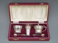 A cased Art Deco style hallmarked silver three piece cruet set,