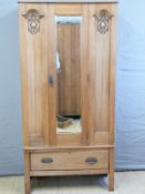 A satinwood Art Nouveau wardrobe with bevelled mirror door and single drawer below,