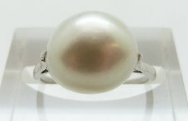 A platinum ring set with a large natural single saltwater pearl measuring approximately 9.9- 10.