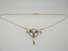 A 9ct gold Edwardian necklace set with aquamarines and seed pearls in a stylised bow design
