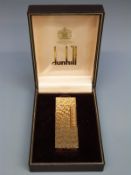 A cased gold pleated Dunhill lighter with retro bark effect finish