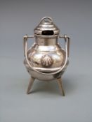 A novelty white metal lidded cauldron with swing handle, raised on three legs,