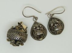 A pair of silver earrings and a silver sphere pendant with filigree decoration