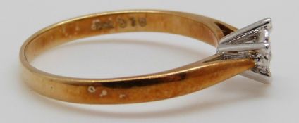 An 18ct gold ring set with a round cut diamond in a star setting, 2.