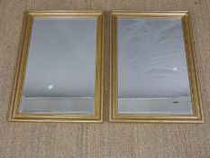 A pair of gilt framed mirrors with bevelled glass,