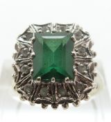 An 18ct white gold ring set with a faux emerald cut emerald surrounded by paste, size Q, 5.