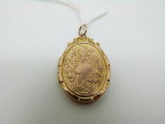 A 9ct gold Edwardian locket with scrolling engraved decoration,