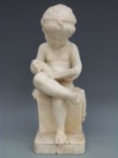 An alabaster figure of a boy reading a book,