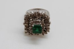 An 18ct white gold ring set with a square cut emerald of approximately 1ct surrounded by baguette