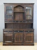 A stained pine dresser with glazed cupboards and four drawers to top,