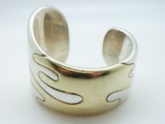 A white metal bi-coloured bangle in a bespoke design with signature to inside