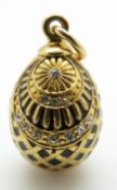 A silver gilt egg pendant set with paste and black enamel,