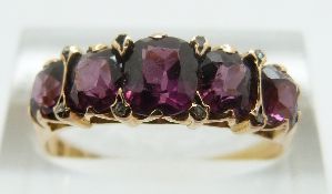 A 15ct gold ring set with five graduated garnets and diamonds (Birmingham 1873), size R/S, 3.