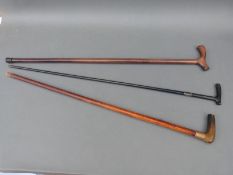 Three sticks including ebonised example with white metal mount,