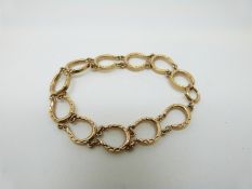 A 9ct gold bracelet made up of 11 horseshoes,