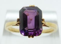 A yellow metal ring set with an emerald cut synthetic purple sapphire, size R/S, 4.