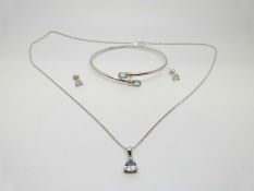 A 9ct white gold bangle set with two aquamarine and a 9ct white gold pendant and chain set with a