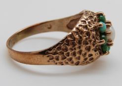 A 9ct gold ring set with a pearl surrounded by turquoise cabochons, size N,