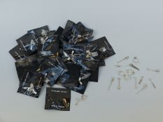 A collection of silver charms including cricket bat, hammer, saw,